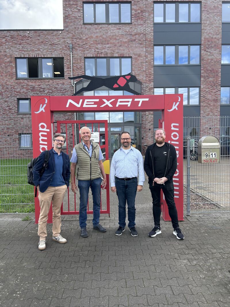 Vier Teilnehmer beim Besuch des LLM4KMU-Projektteams vor dem Eingang der NEXAT GmbH